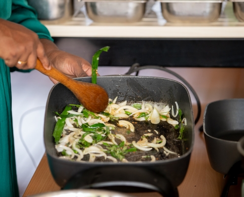 Karunika Pemarathne stirs vegetables in a pan